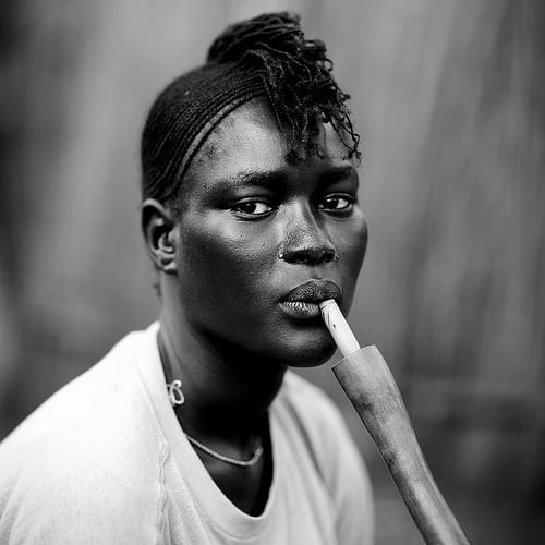 Miss Ariet, Anuak refugee, smoking pipe, in Dima, Ethiopia